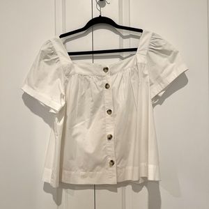 White top with brown buttons and caps sleeve.